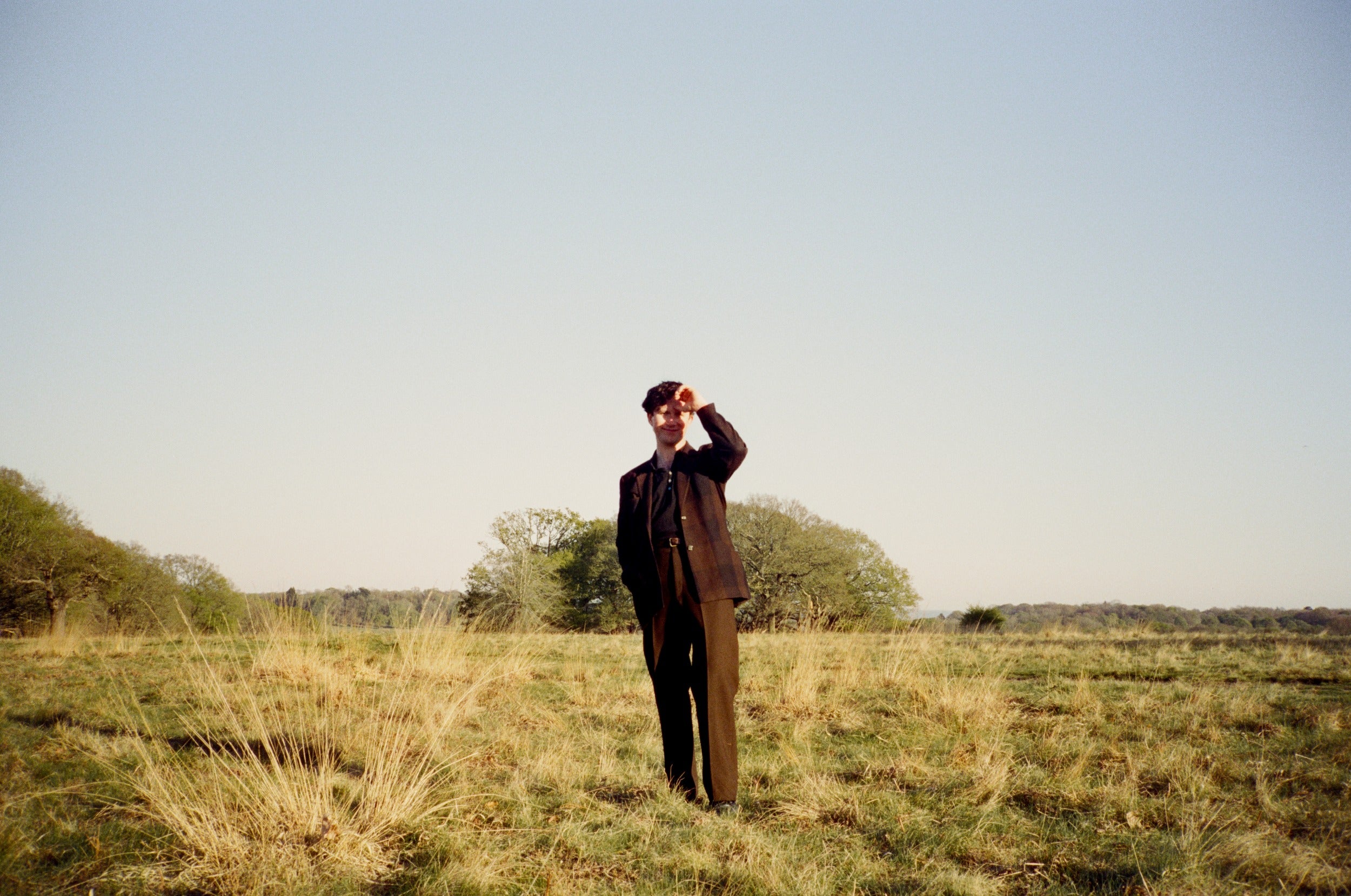 MT Jones standing in a field with trees and clear sky